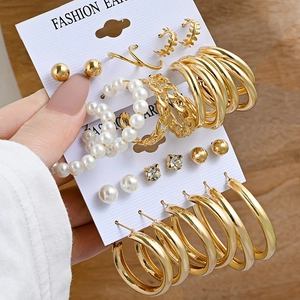 Vintage gold geometric earring set with pearls and rhinestones on a wooden background