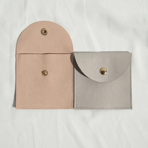 Microfiber jewelry pouches in pink and grey with secure gold snap button closure