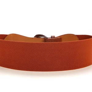 Close-up of orange elastic waist belt with brown leather buckle and metal hardware
