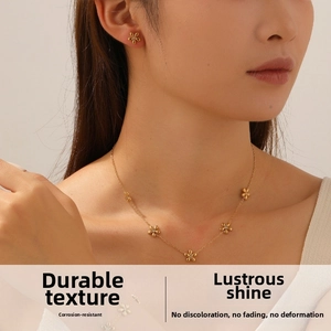 Detail of elegant gold flower necklace and earring set worn by a model in light luxury style