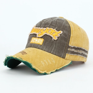 Detail view of distressed baseball cap with New York embroidery and frayed brim edge
