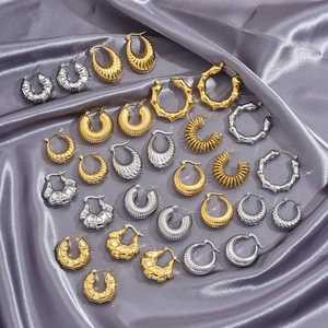 Vintage stainless steel hoop earrings in gold and silver colors on silk fabric