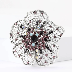 Detailed view of flower brooch with colorful rhinestones and intricate silver hollow design