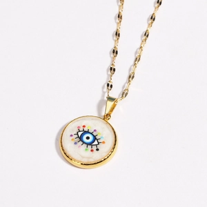 Detail of gold stainless steel necklace with round evil eye pendant and colorful accents