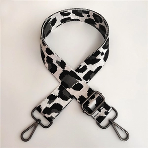 Close-up of leopard print fabric strap with adjustable gunmetal buckle and swivel hooks