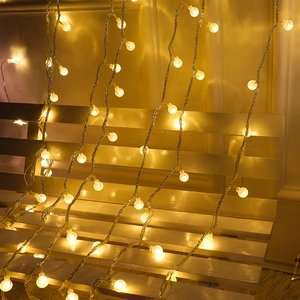 Warm white LED curtain lights with transparent sphere bulbs for festive indoor decoration