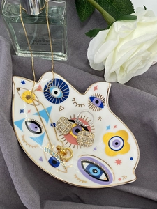 Dettaglio del vassoio per gioielli in ceramica a forma di Hamsa con motivi Evil Eye