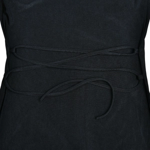 Détail du laçage au dos d'une robe noire avec des attaches réglables et élégantes