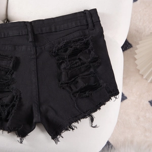 Detailed back view of black distressed denim shorts with ripped holes and frayed hems
