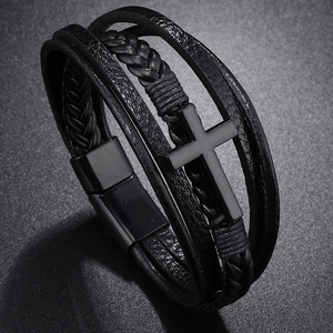 Macro detail of multi-layer black leather bracelet with cross and magnetic clasp