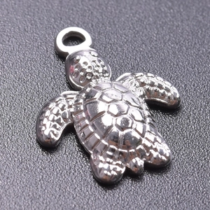 Macro shot of silver stainless steel sea turtle pendant with detailed shell texture