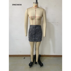Detail of grey mini skirt featuring multiple decorative zippers and washed fabric texture