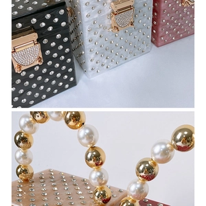 Detail of luxury acrylic evening bag with sparkling rhinestones and pearl handle