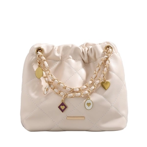 Quilted cream bucket bag with gold chain strap and decorative heart charms