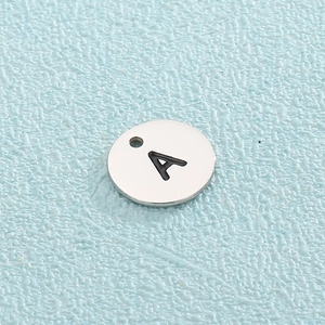 Detail shot of silver titanium steel round pendant with letter A engraving for DIY jewelry