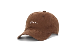 Close-up of brown corduroy baseball cap with white 'me' embroidery and vintage stitching