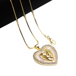 Detail of gold heart pendant with mother-child shell inlay and sparkling zircon border