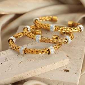 Braided gold titanium steel open bangle featuring sparkling rhinestone ring pendants