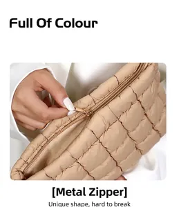 Détail de la pochette matelassée beige avec une fermeture éclair en métal doré de qualité