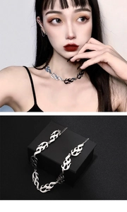 Detail view of silver flame link necklace on model and in a black display gift box