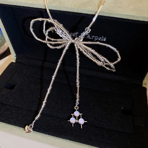 Detailed close-up of handmade crystal beaded bow necklace with a silver heart pendant