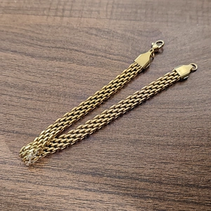 Détails de deux bracelets en maille d'acier inoxydable doré 18 carats avec fermoirs mousquetons