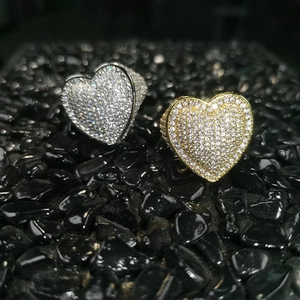 Close-up of gold and silver heart rings with AAA zircon paving on black stones