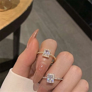 Detailed view of square halo rings in gold and silver finish with pave-set zircon stones