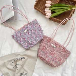 Vue détaillée des sacs fourre-tout en toile florale avec ordinateur et tulipes sur tissu