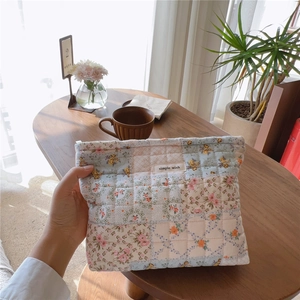 Dettaglio della borsa per cosmetici trapuntata a fiori con etichetta simple wish