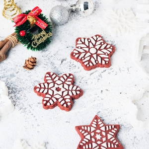 3D snowflake and star Christmas cookie cutters with red festive frosted biscuits