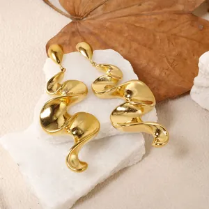 Gros plan détaillé de boucles d'oreilles spirales plaquées or 18K sur pierre blanche