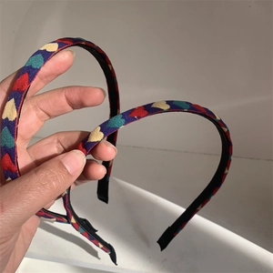 Detail of colorful heart pattern on blue fabric headband for face washing or styling