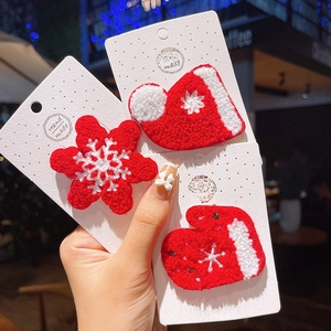 Detailed close-up of knitted Christmas hair clips featuring snowflake, sock, and glove designs