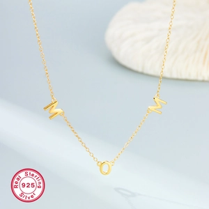 Minimalist S925 sterling silver gold-plated MOM letter necklace for women on grey background