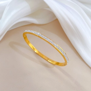 Close-up of gold plated titanium steel bangle with full paved sparkling white zircons