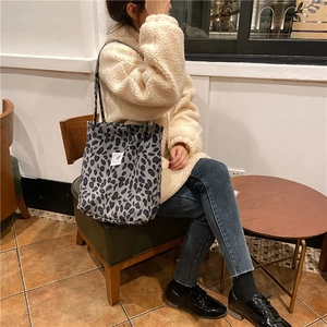 Detail of grey leopard print corduroy tote bag showing soft texture and snap button closure