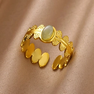 Macro detail of 18K gold plated ring featuring green stone on silk background