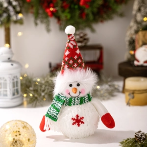 Close-up of glowing plush Christmas snowman with red snowflake embroidery and warm lights