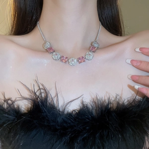 Detail of silver necklace with pink square gemstones and zircon flowers on a model