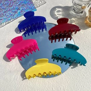 Nahaufnahme bunter Haarklammern aus Acetat in Katzenform in Pink, Blau, Rot und Gelb