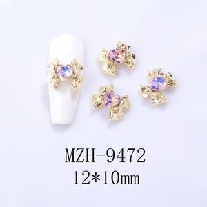 Close-up of 12x10mm alloy bow nail charms with iridescent heart crystals on model