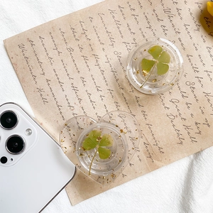 Detail of heart and round phone sockets featuring real green clovers and gold foil