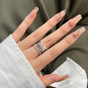 Silver bow ring with pink gem and zircon eternity band worn on model hand in soft setting