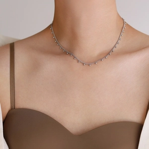 Close-up of minimalist silver bead choker necklace on model for delicate layering