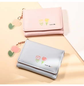 Close-up of pink and blue PU leather wallets with tulip prints and matching keychains