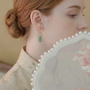 Elegant gold earrings with green aventurine beads in a vintage Chinese style on model