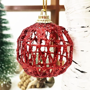 Macro view of red hollow glitter Christmas ball ornament with golden hanging string