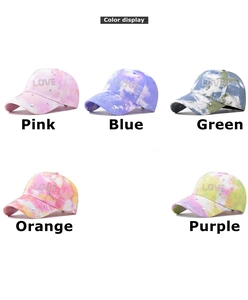Close-up of five colorful tie-dye baseball caps featuring rhinestone LOVE embellishments