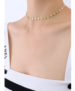 Detailed macro view of 18k gold floral choker with sky blue enamel petal centers